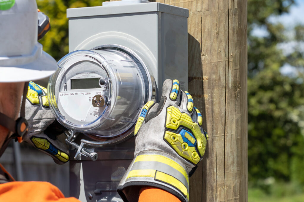 Utility power lineman installing a standard service electrical meter