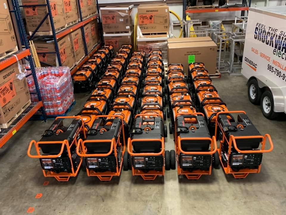 A warehouse filled with rows of orange and black portable generators.